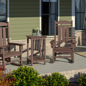 Two chairs and a square counter table on a patio with a house in the background
