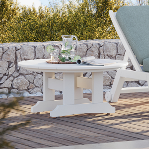 White outdoor coffee table with a green cushioned chair on a wooden deck.