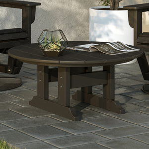 Round outdoor coffee table with chairs on a stone patio