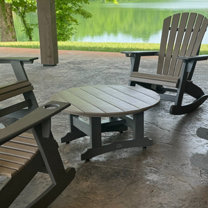 Outdoor patio set with table and rocking chairs on a concrete patio.