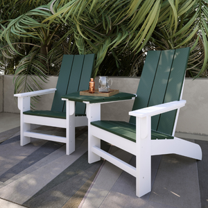 Two green and white chairs on a patio with a small table between them.