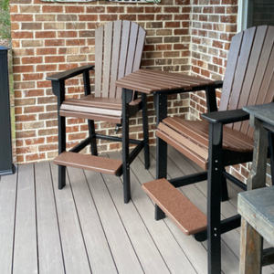 Outdoor furniture set with bar chairs and a small table on a wooden deck against a brick wall.
