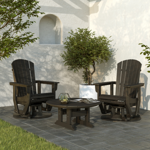 Two glider chairs and a table on a patio with a white wall and tree in the background.